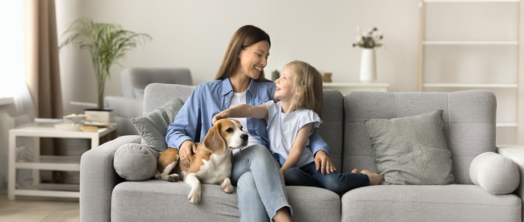 Mother and daughter bonding with a dog, showcasing pets’ emotional health benefits