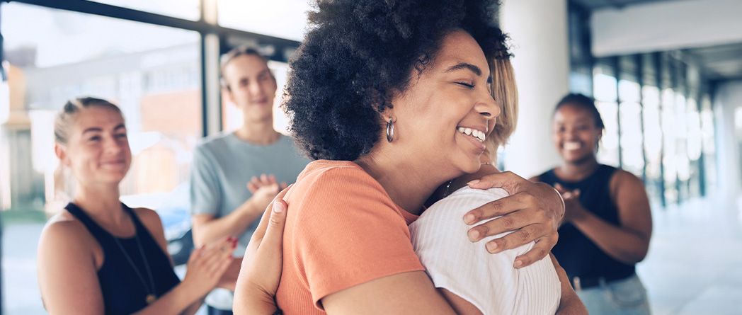 Group embracing, symbolizing support and emotional connection in therapy