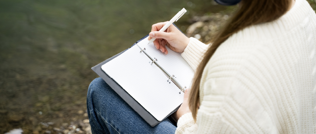 Woman writing thoughts in a journal during quiet reflection