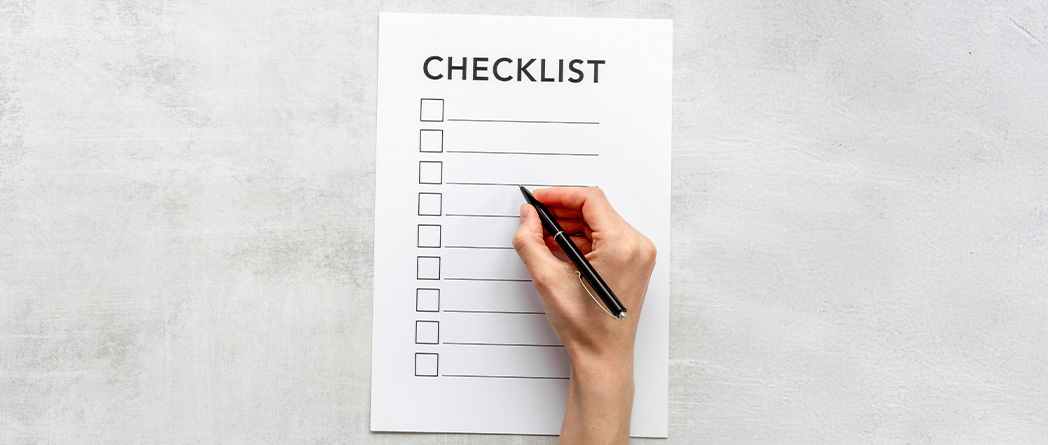 Checklist being filled out by hand with a pen