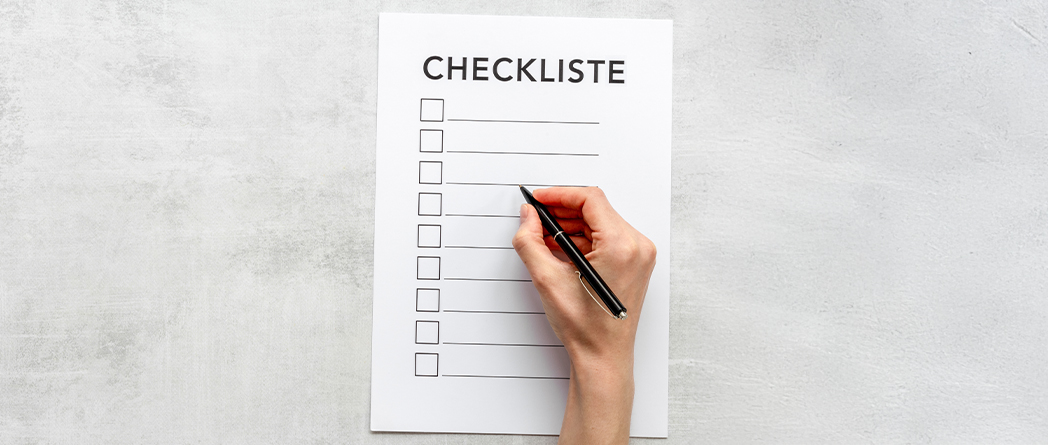 Checkliste, die von Hand mit einem Stift ausgefüllt wird