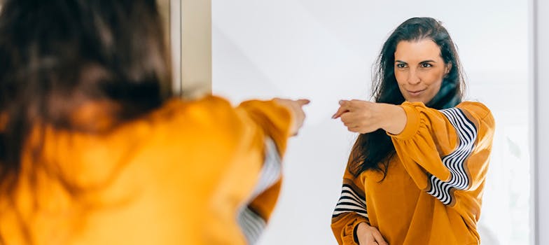 Person looking at confident version of themselves in the mirror, representing overcoming imposter syndrome